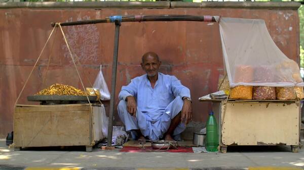 坐在印度街的食品摊上的老人