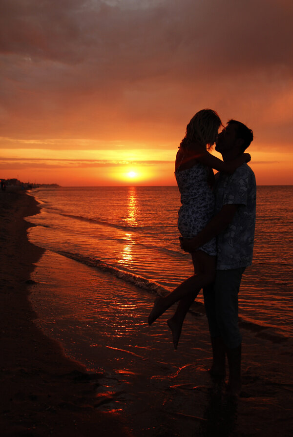 黄昏沙滩拥抱的情侣