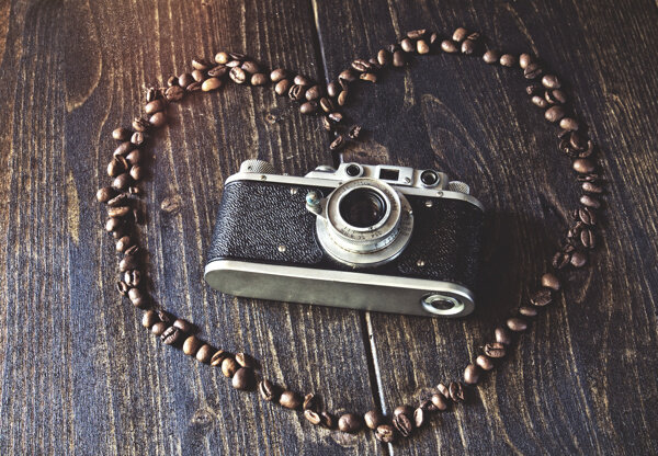木板上的心形咖啡豆与相机图片