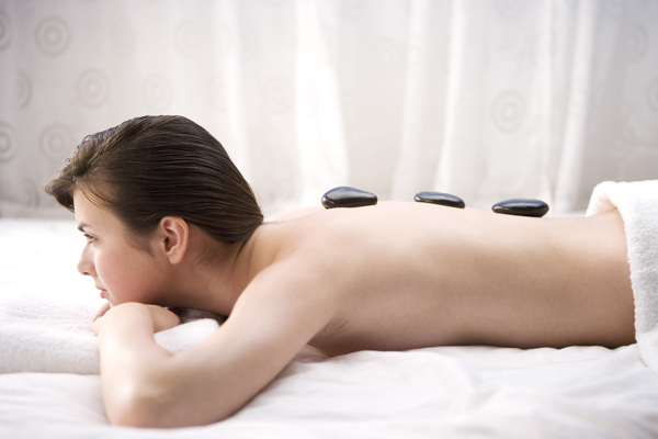 趴在床上做火山石疗法的半裸女人图片
