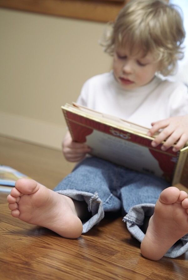 坐在地板上看书的男孩图片