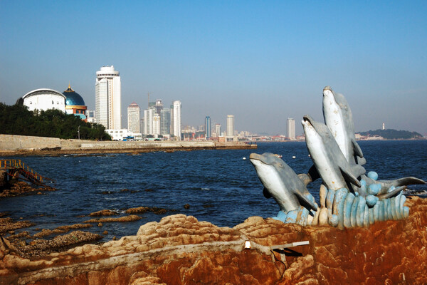 海豚雕塑与海边建筑相图片