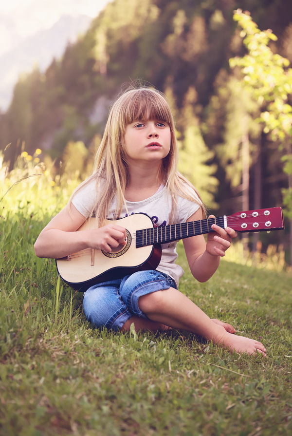 草坪上弹吉他小女孩图片