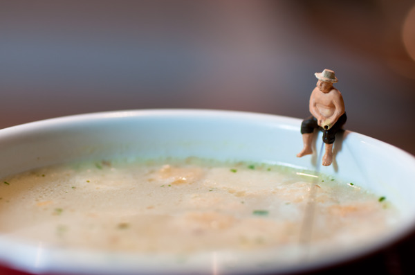 雕像捕鱼的渔夫在汤的杯子