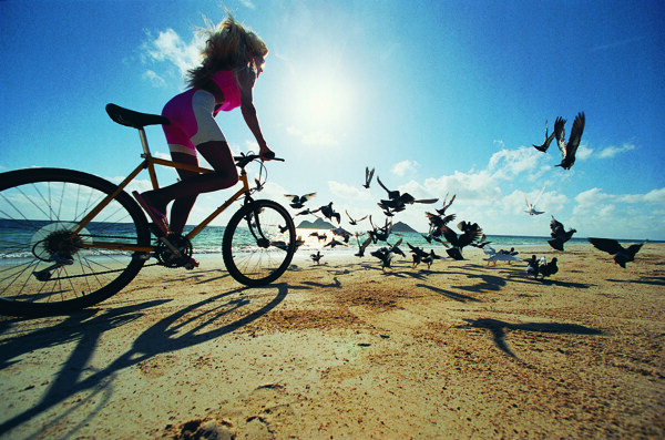沙滩骑自行车的时尚美女图片