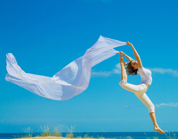 沙滩舞动丝绸跳跃的美女图片