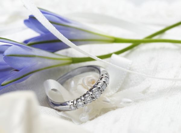 两朵蓝花旁的钻石戒指图片