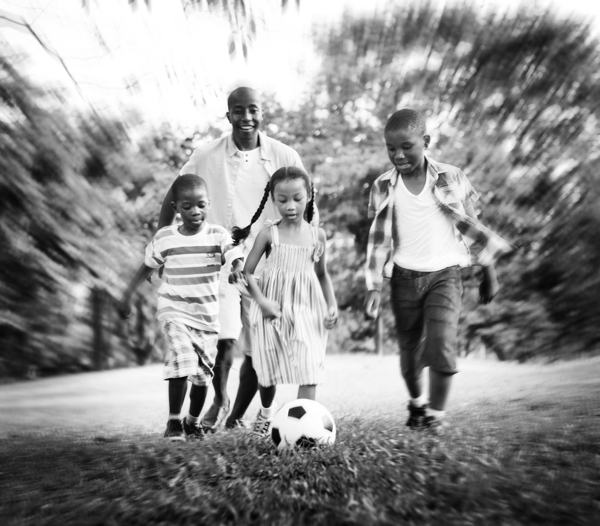 草地上踢足球的一家人图片
