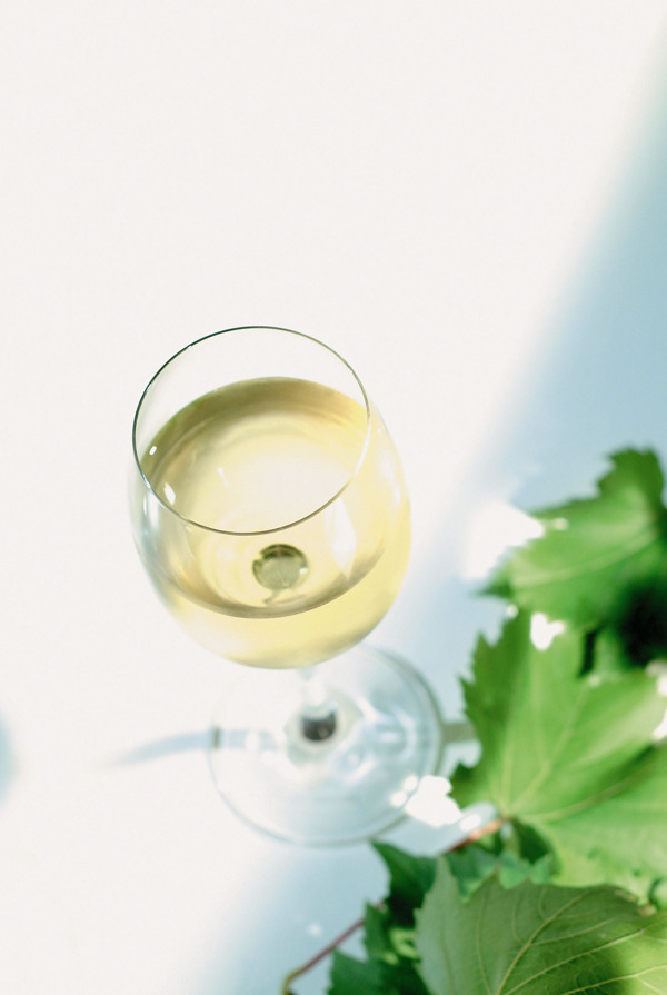 葡萄叶旁的一杯葡萄酒图片